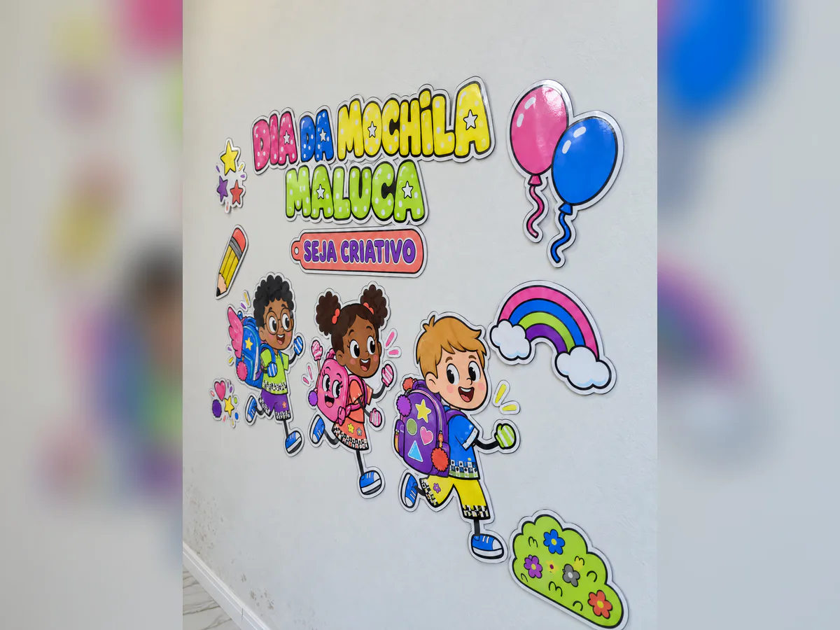 Painel Dia da Mochila Maluca visto pela direita, com título colorido, crianças com mochilas, arco-íris, balões e enfeites.